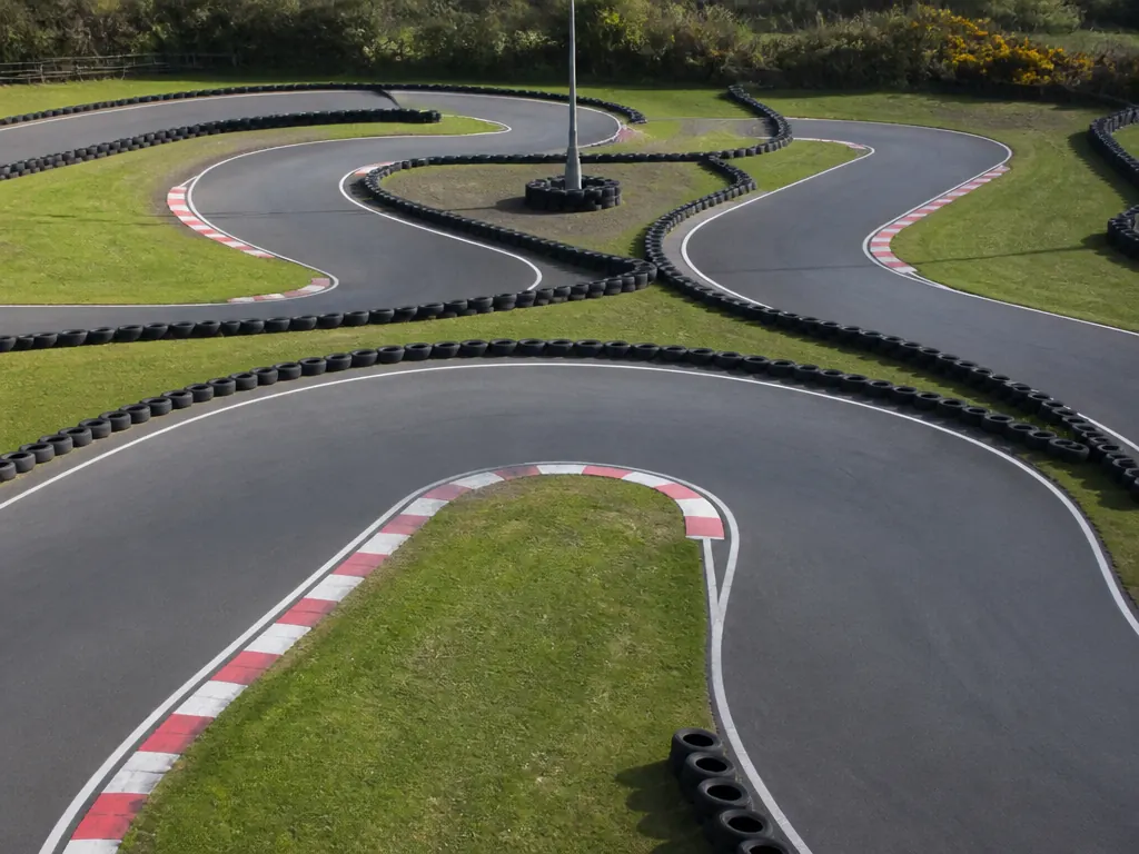 Gokart i full fart genom en kurva på asfaltbana, genrebild