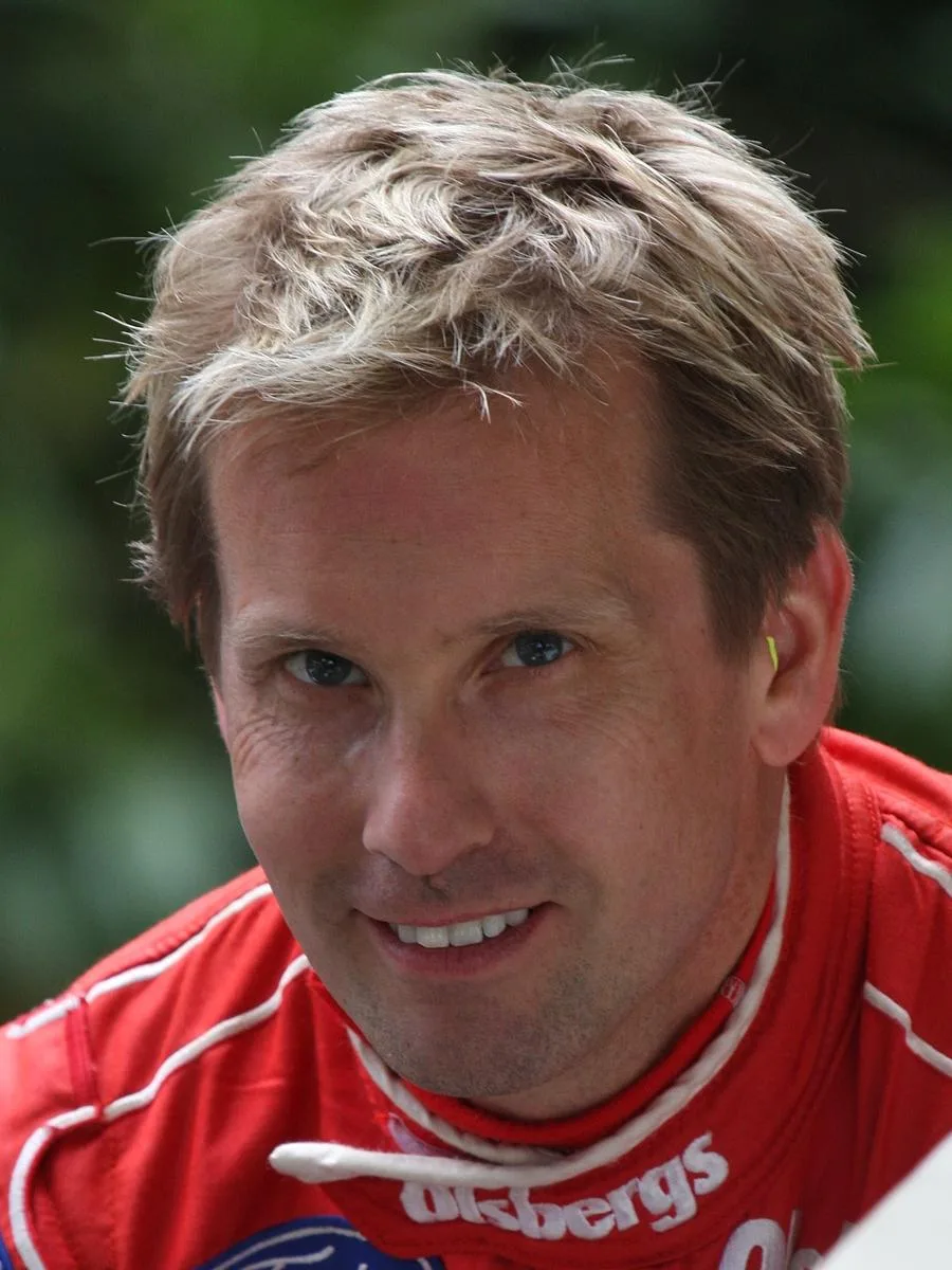 Kenny Bräck i röd tävlingsoverall vid Goodwood Festival of Speed i England 2011